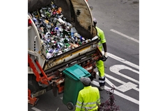 Image Garbage men collecting trash into their truck.